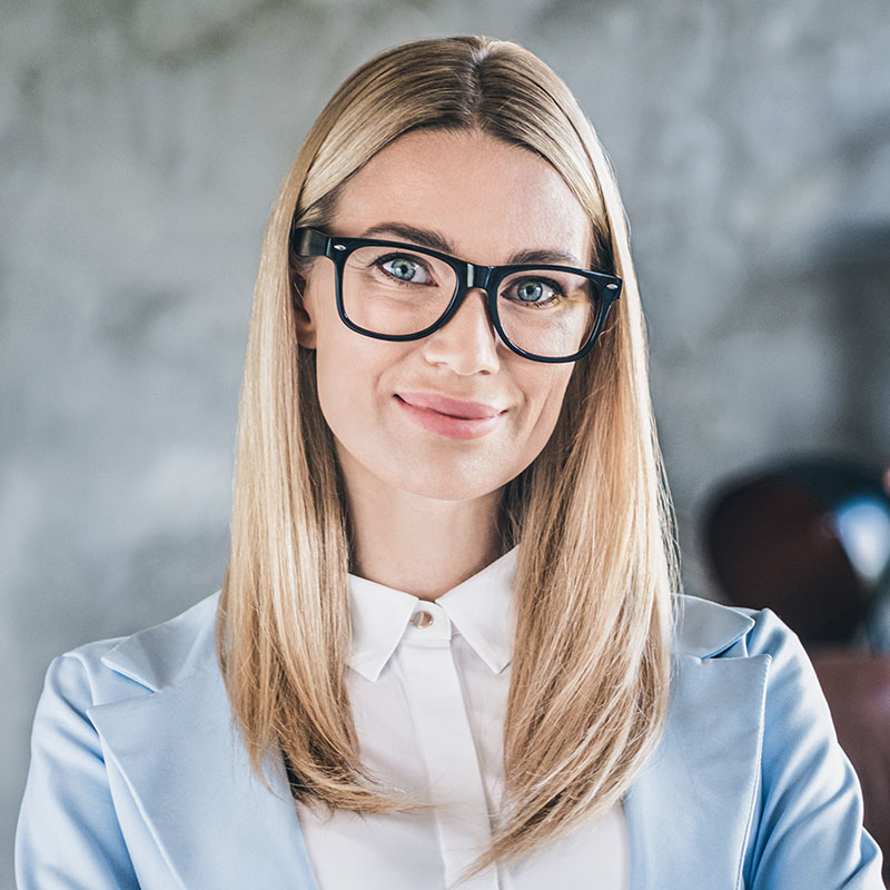 Blonde Frau mit Brille lächelt in die Kamera