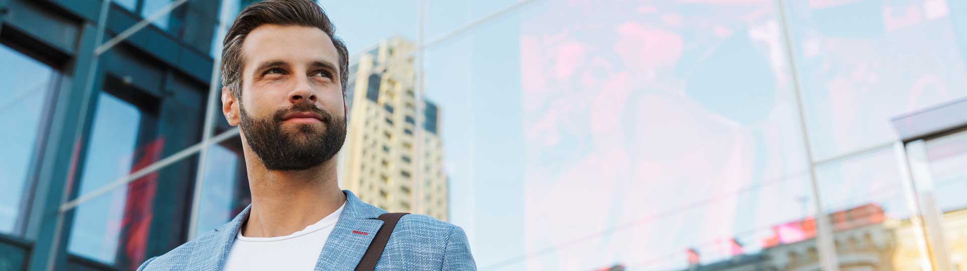 dynamischer Mann aus dem Aussendienst vor Glasfassade