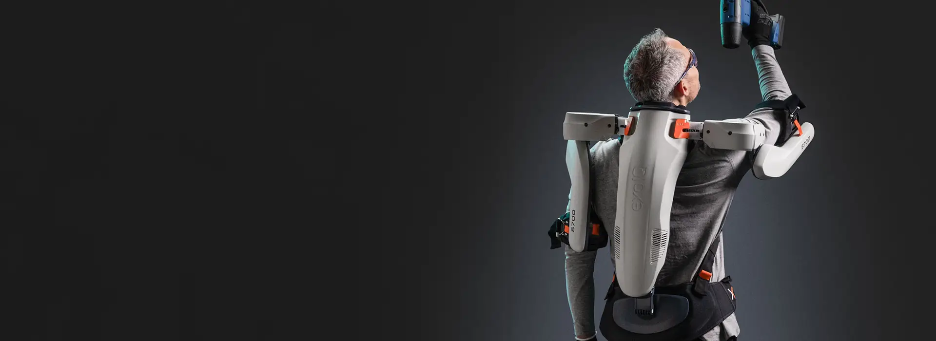 Mann von Hinten in Studio trägt Exoskelett