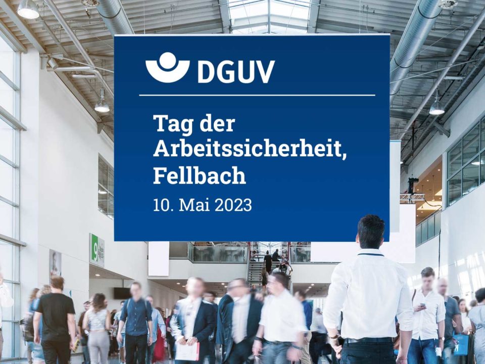 Bild Messe. Mann steht vor Schild Tag der Arbeitssicherheit