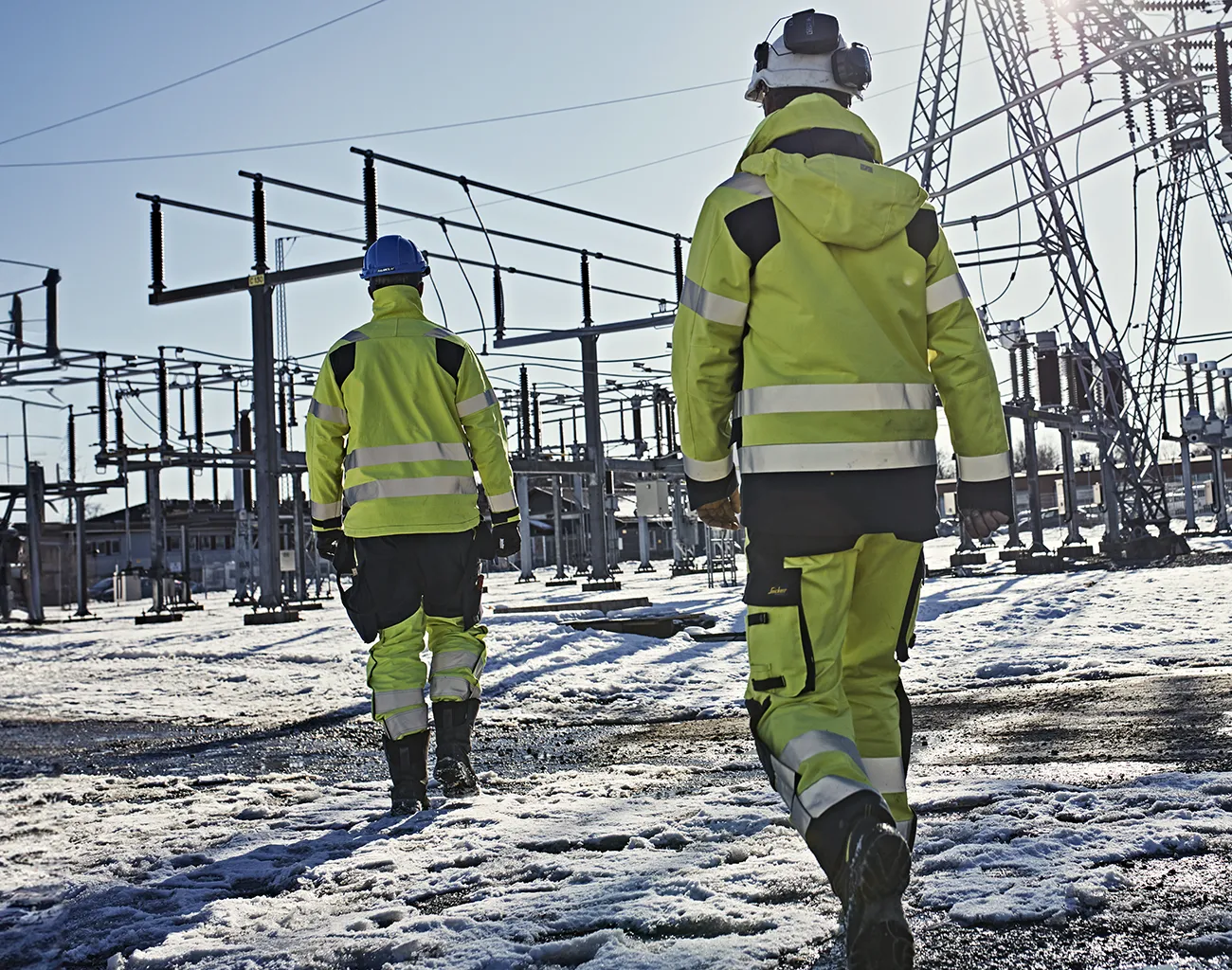 Mann läuft im Schnee mit High-Visibility Kleidung