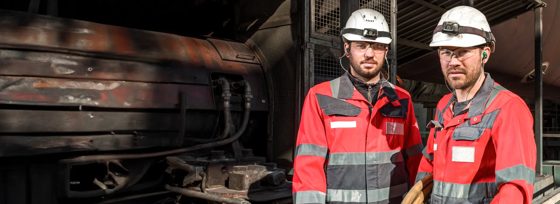 2 Arbeiter aus der Industrie in Schutzkelidung, Helm und gehörschutz im Ohr