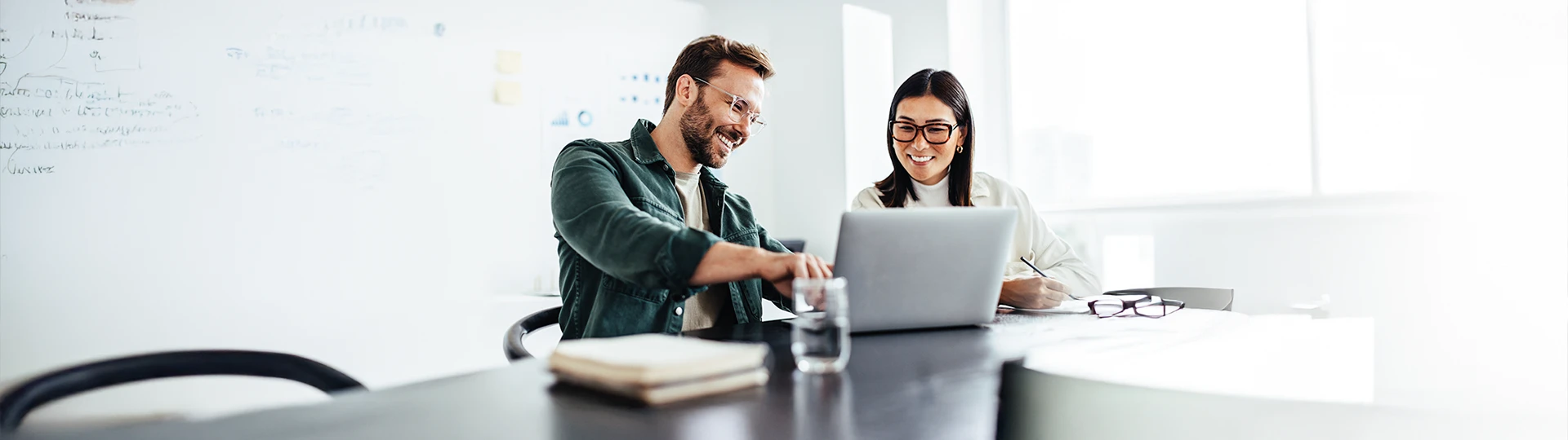 2 Datenmanager (Mann und Frau) sitzen vor einem Laptop